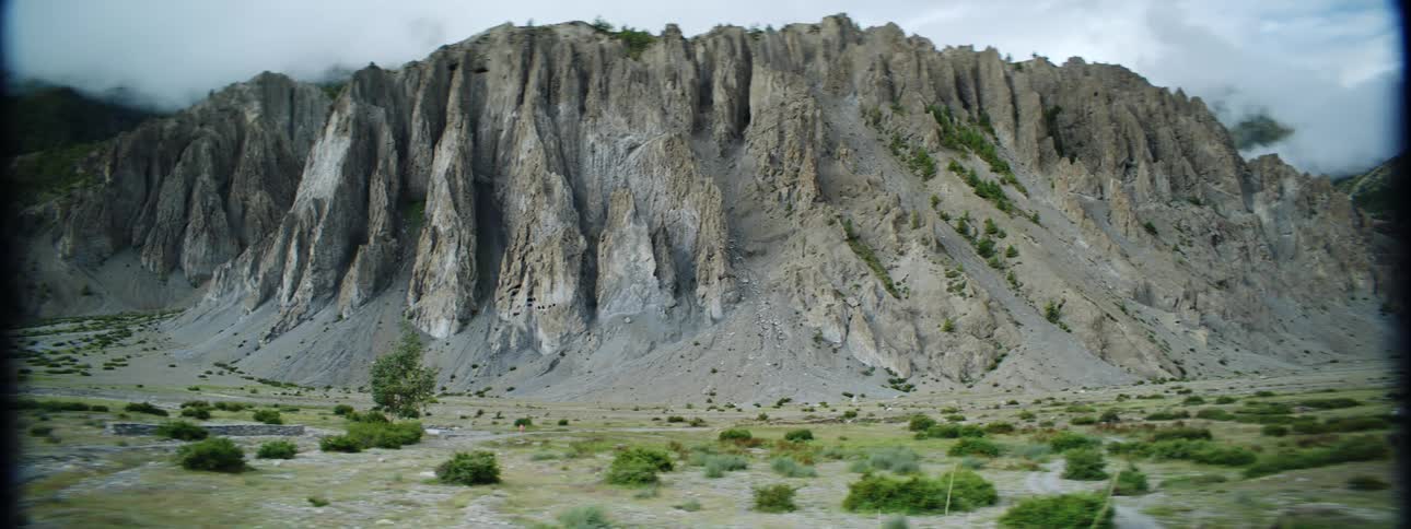 Dense clouds settle along the top of a tall cliff