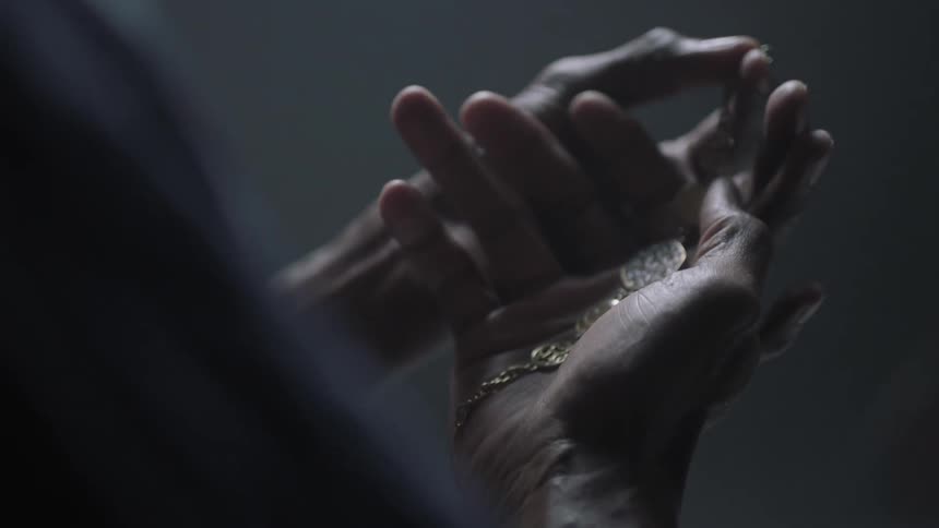 A person's hands are holding a necklace