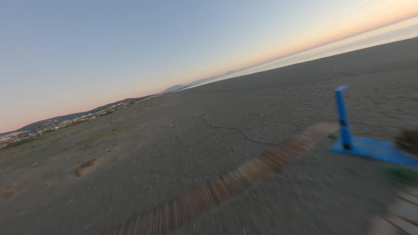 Aerial drone time lapse video of a flight over a sandy ocean beach at sunset