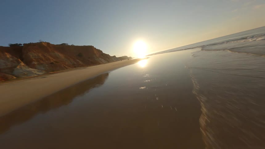 Aerial view of a beach while the sun is setting