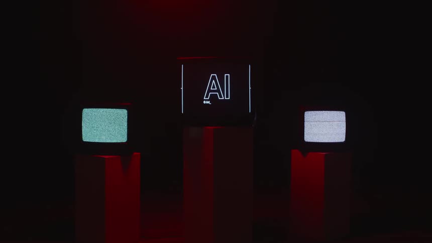In dark room on pedestals two older televisions show signal static while newer central screen show the letters ai