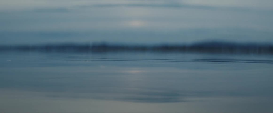 Close up of small waves and ripples on the surface of a lake at morning