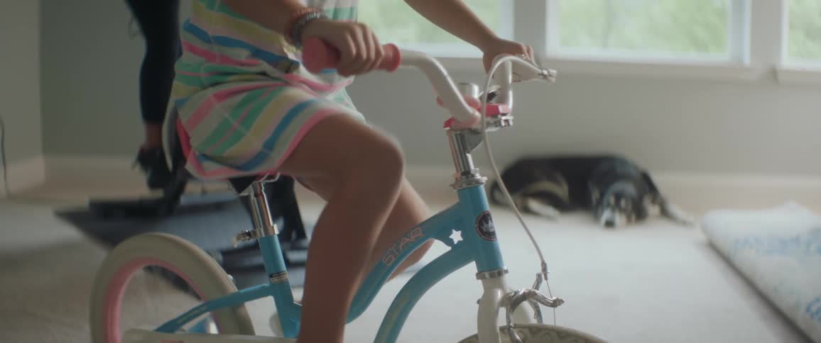 Little girl exercising indoors on a childs stationary bike