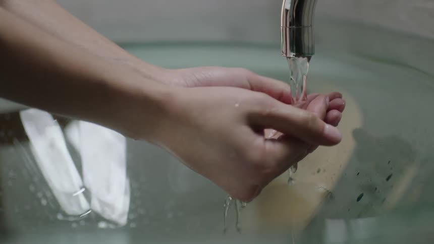 Cupped hands reaching under a faucet to catch water