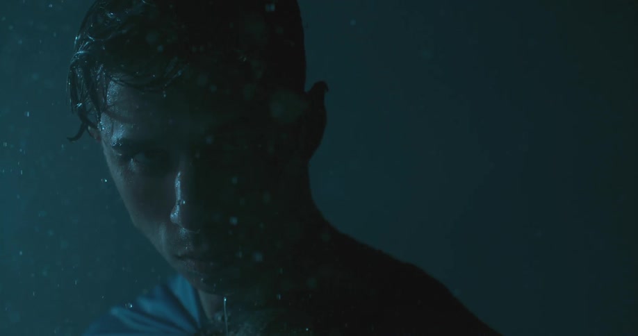 Rain falls on a man who looks up