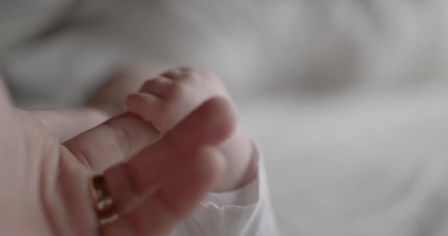 A person holds a babies hand