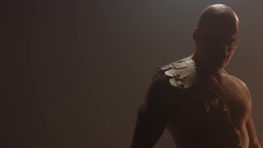 Shirtless man standing with a leather piece over one shoulder