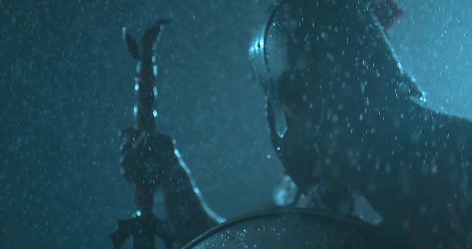 A man wearing a helmet is standing in the rain
