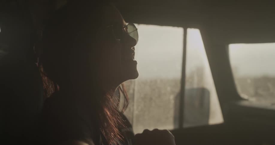 A woman in sunglasses riding in a car