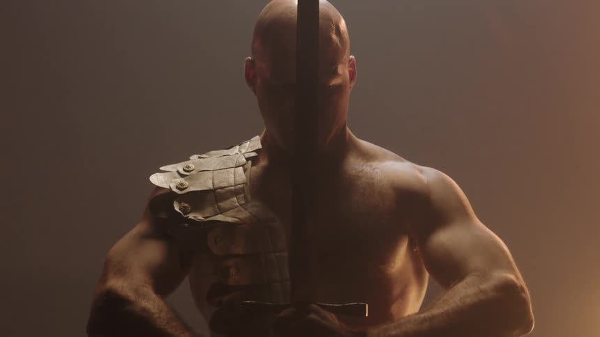 An angry looking man raises a sword