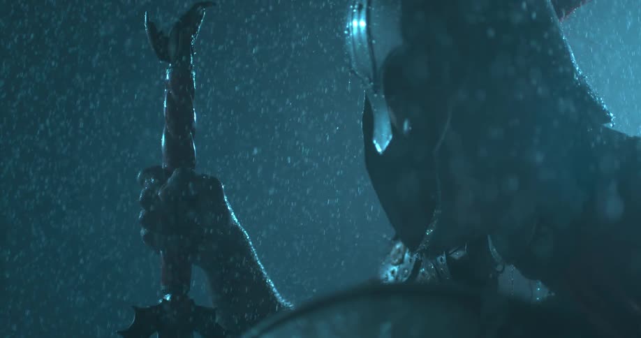 A man wearing a helmet has a sword and shield in the rain