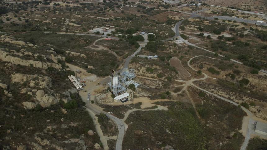 An epic aerial shot tilting down on the abandoned and rundown Rocketdyne Aerospace Testing Facility in Brandeis California during summer