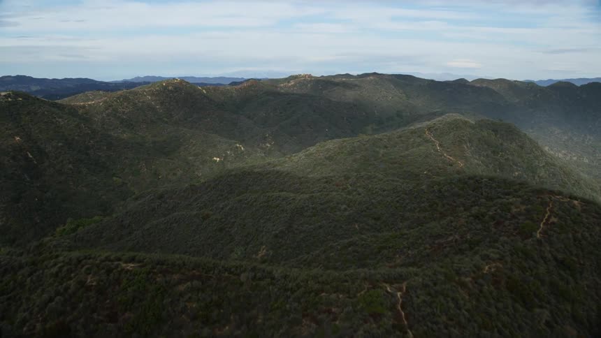 Aerial footage of the rolling green Santa Monica Mountains in California during a cloudy day