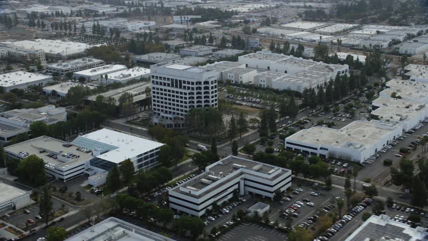 Aerial footage of an office building in Chatsworth California captured during daytime with a hazy and industrial setting