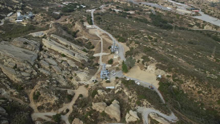 Aerial footage of Rocketdyne Aerospace Testing Facility on a hilltop in Brandeis California with the radio control towers visible