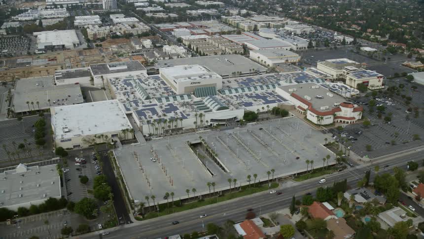 Orbiting aerial view of Northridge Shopping Mall and Macys retail centers in Southern California on an overcast day