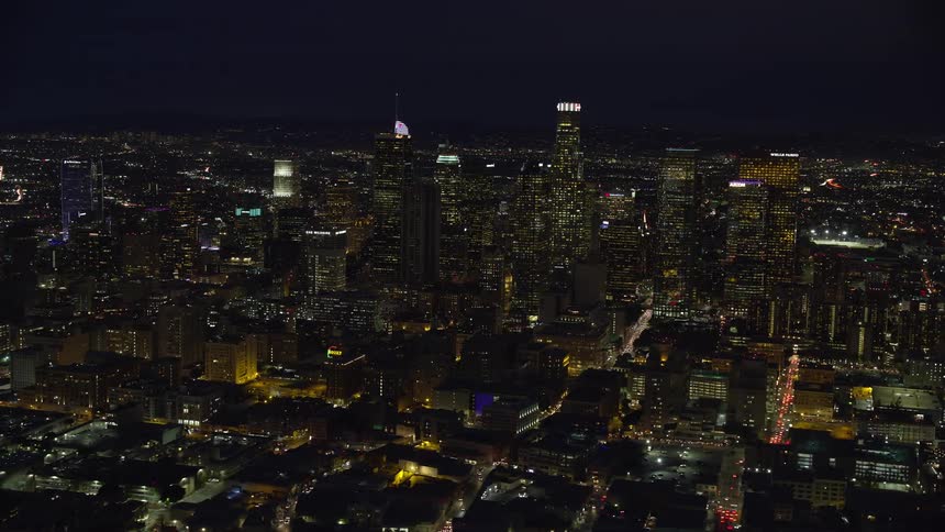 Flying over the illuminated skyscrapers of Downtown Los Angeles California during a clear night