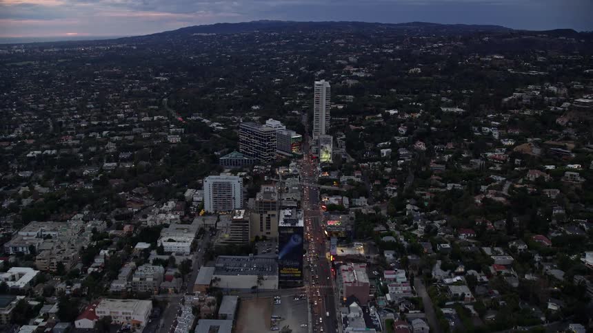 An aerial shot of Sunset Boulevard approaching the Sunset Strip during twilight in West Hollywood California