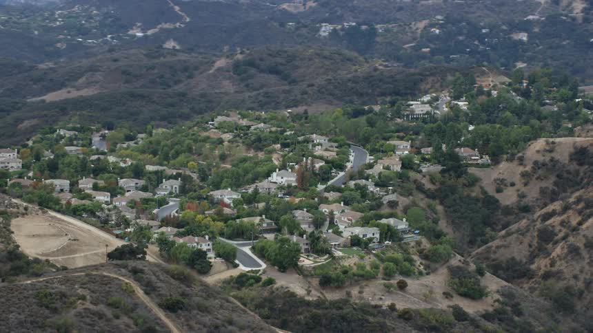 Aerial footage of homes on a cloudy hillside in Topanga California