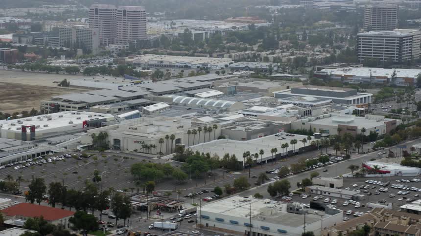 Aerial footage orbiting Macys at Westfield Topanga Mall in Woodland Hills California on a cloudy day during spring or summer shopping season
