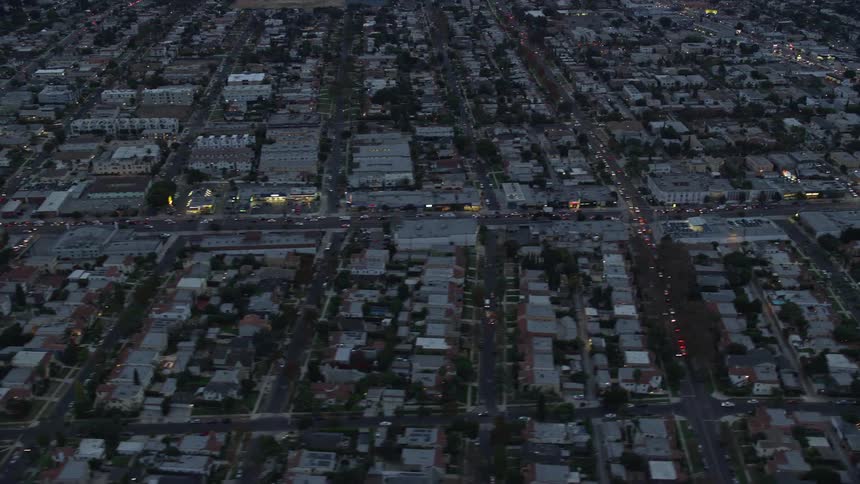 This aerial footage provides an impressive view of Central Los Angeles as the camera flies over businesses and residential areas along La Cienega Boulevard and West Pico Blvd during twilight