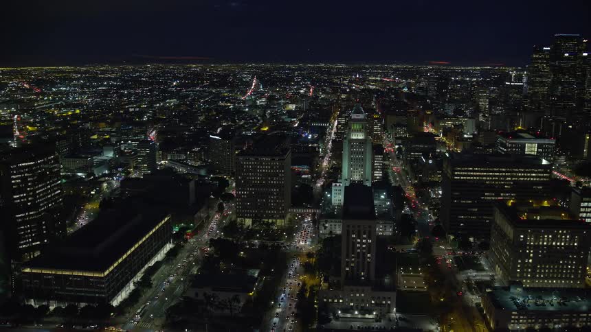 A stunning aerial view of Downtown LA at night with the iconic City Hall building visible in the center