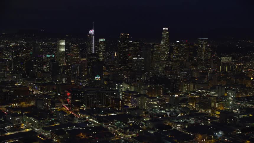 A stunning aerial footage at night of Downtown Los Angeles capturing the grandiosity of the citys high rise skyscrapers shot from the south of downtown