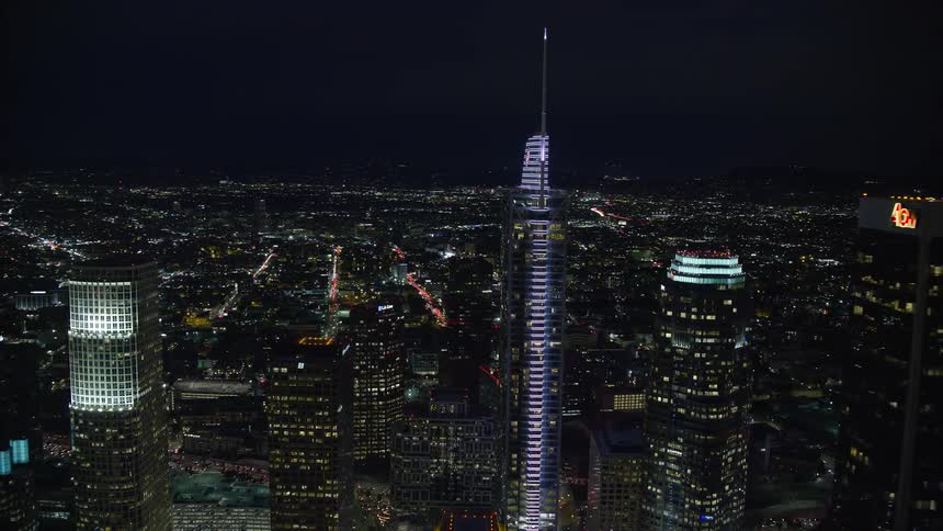 A clear night-time aerial shot approaching Aon Center which reveals the towering superstructure of Wilshire Grand Center in Downtown Los Angeles California