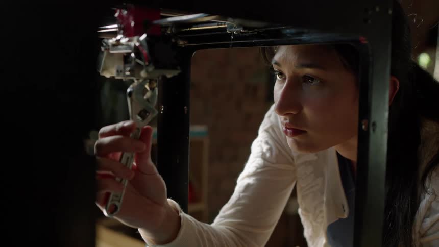 Woman repairing an engine and looking focus