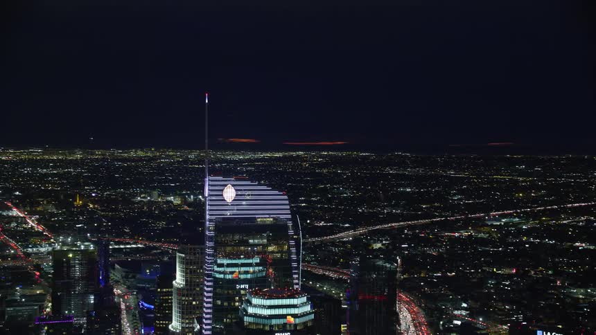 A aerial footage showcasing the Wilshire Grand Center US Bank Tower and other skyscrapers in the clear night sky over Downtown Los Angeles California