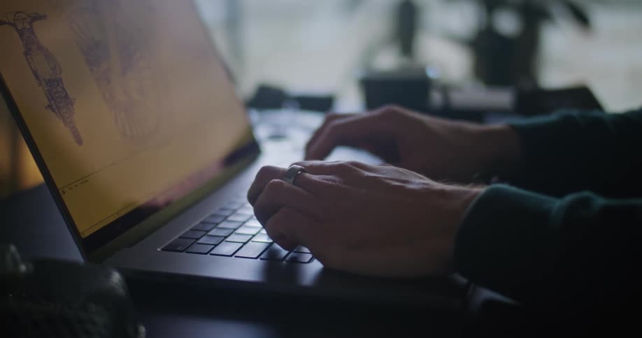 A persons hands typing on their laptop keyboard as there is an image on the screen