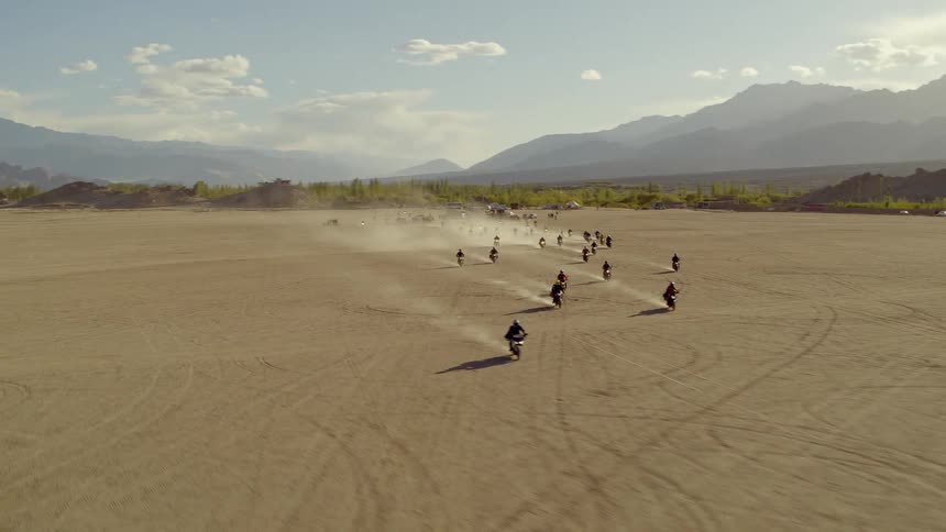 Large group of motorcycle riders riding across the desert