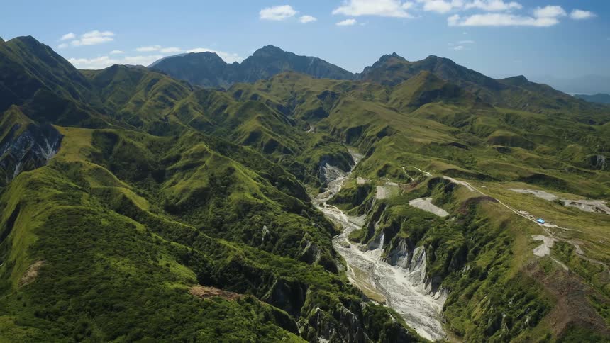 Panoramic view of green mountains and a valley midday