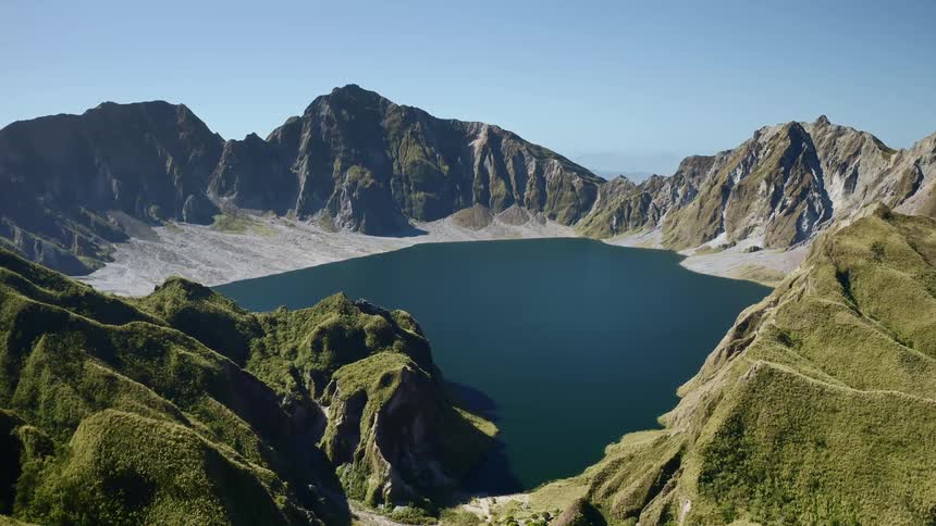 Vegetation covered mountains surround lake on multiple sides
