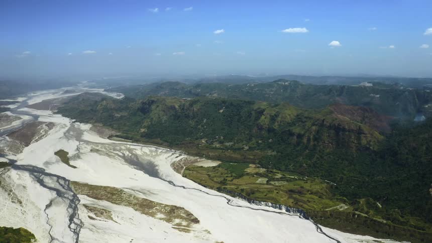 Several rivers wind their way through a canyon between sprawling mountain ranges