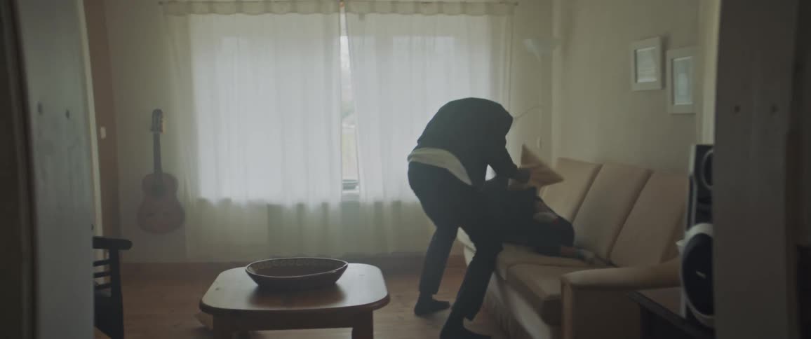 Black father and child playing around with pillows on the couch