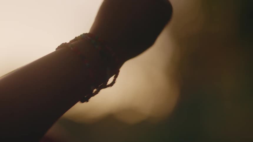 An up close of a persons arm wrist and hand playing with bracelets on their wrist