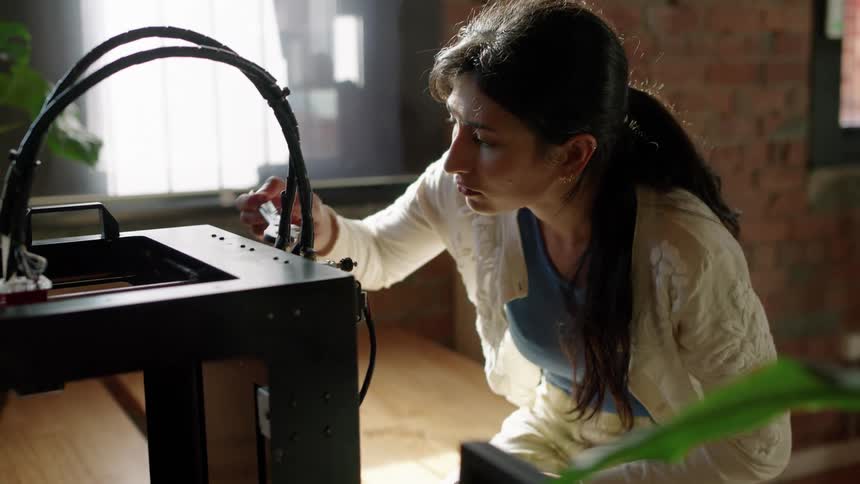 A woman is fixing some cables on her desk