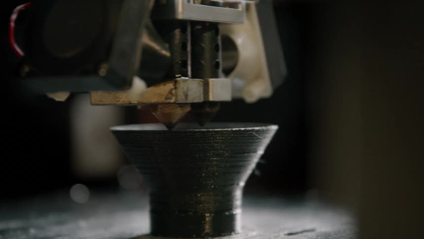 Close up of a piece being printed with plastic filament on a 3d printer
