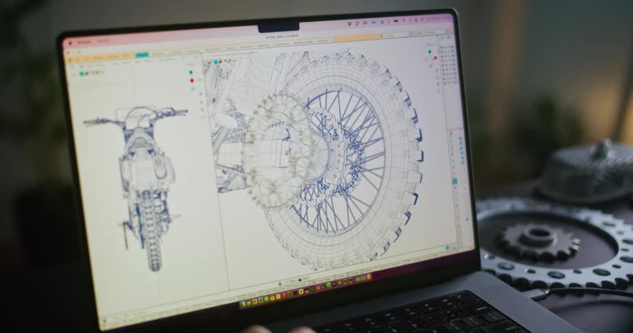 Man uses laptop working on 3d bike wheel and tire