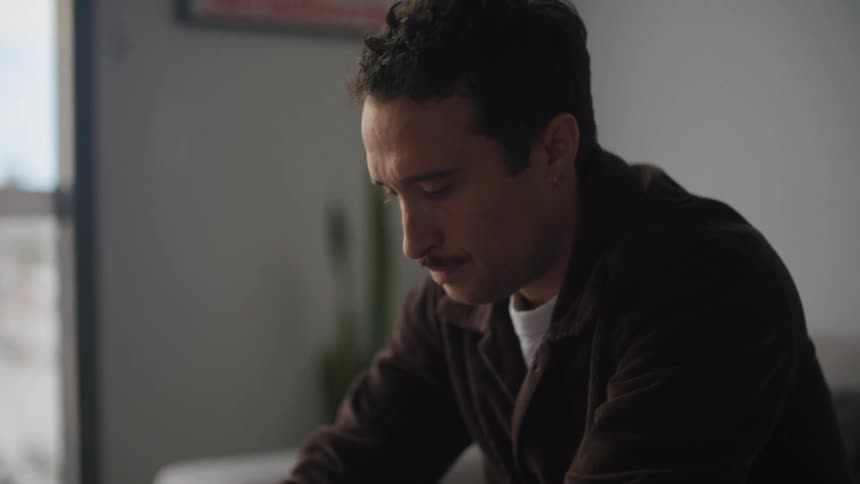 A man is at his desk and looking at a book