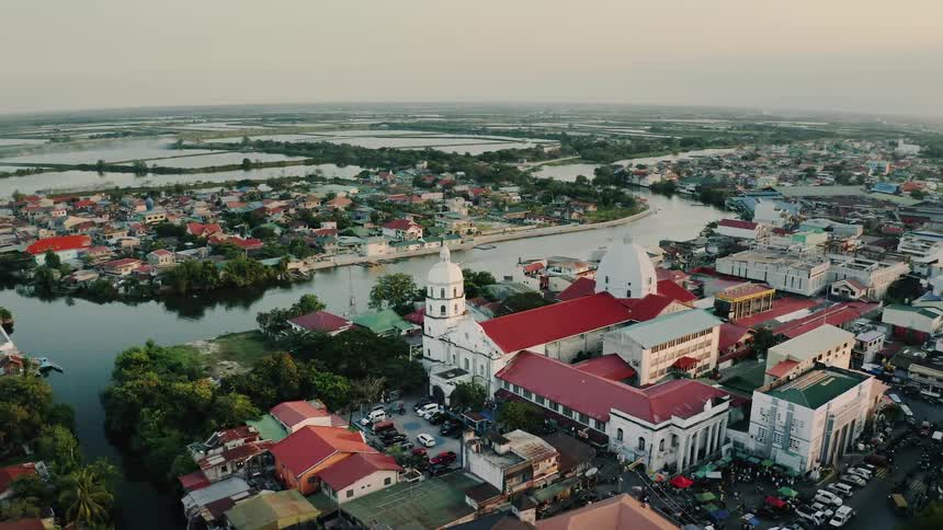 A large residential area with sections separated by waterways expands out below with a large white building with white domes and a red roof in the center