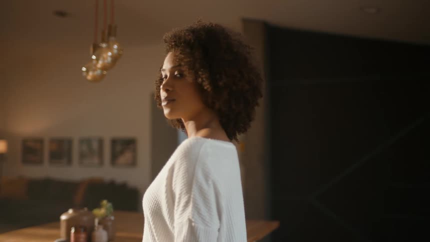 A young lady with a smile on her face in a room radiating happiness and contentment