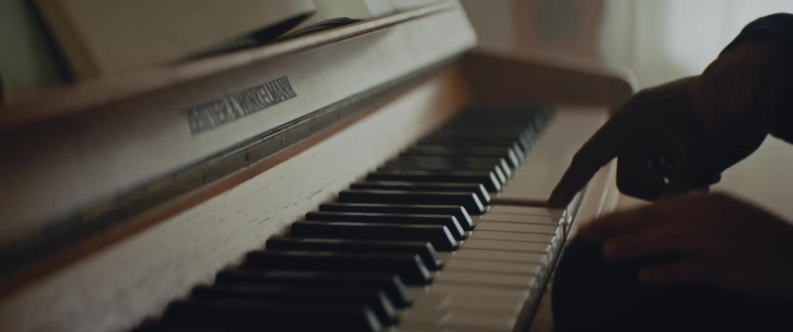 Close up view of a person playing the piano is displayed