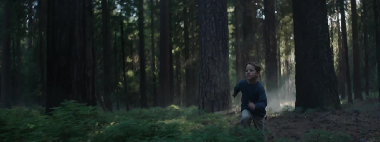 Young boy running quickly through the forest