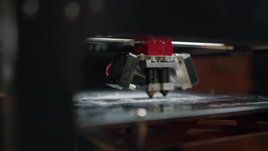 A machine engraves a slab of metal