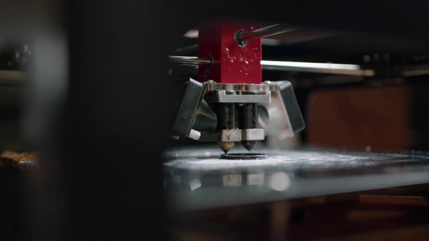 A large automated machine grinds a piece of metal into shape