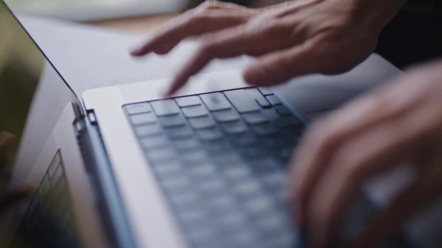 A person is typing on their laptop