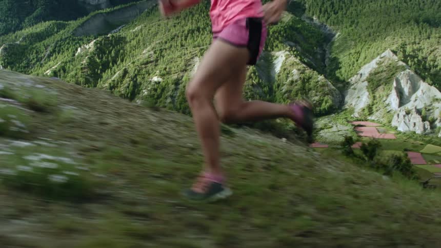 A woman runs up the side of a canyon