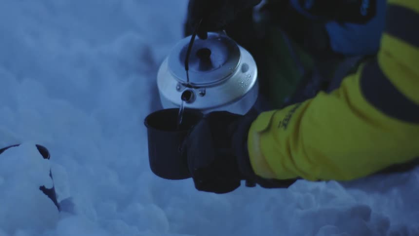 A Couple Pouring Water in the Snowy Wilderness